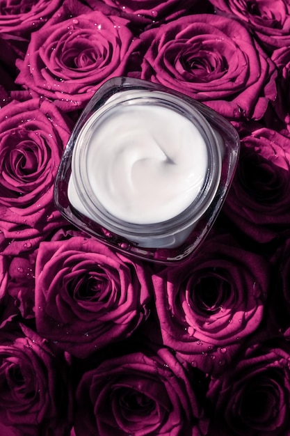 Hidratante de pele creme facial em rosas cor de rosa flores produto cosmético de luxo para a pele em fundo floral como design flatlay de férias de marca de beleza