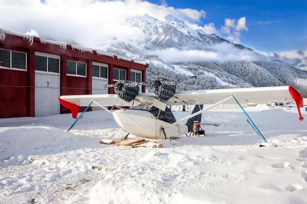 Hidroavião de resgate branco com trem de pouso de esqui nas montanhas de inverno