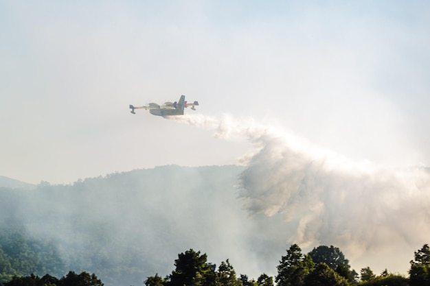 Hidroavião lançando água durante um incêndio florestal