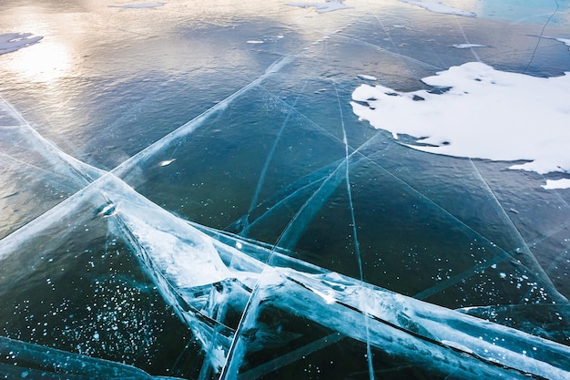 Hielo azul en el lago congelado al atardecer. Hermoso paisaje de invierno