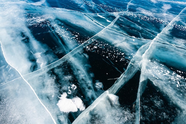 Hielo azul transparente con grietas en el lago Baikal en invierno