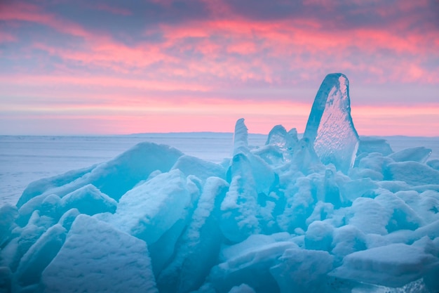 Hielo azul transparente en el lago Baikal al amanecer Nubes rosadas y hielo azul con nieve