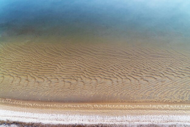 Hielo fino sobre el agua de un pozo de arena con un fondo arenoso transparente Región de Leningrado Vsevolozhsk