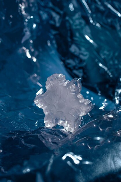 Foto hielo en forma de copo de nieve sobre un fondo azul