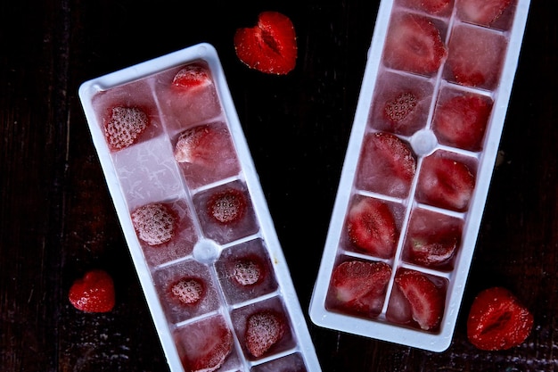 Hielo de fresa en las formas Preparación de hielo de verano para helados de cóctel y postres Espacio de copia