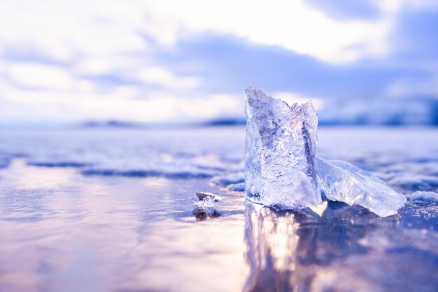 Hielo en el lago congelado al atardecer. Imagen macro, profundidad de campo baja. Fondo de naturaleza de invierno