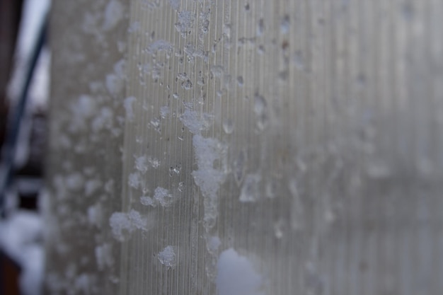 Hielo y nieve en la pared de cristal de la casa.