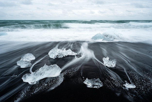 Hielo en la playa con arena volcánica negra cerca de la laguna glaciar de Jokulsarlon Islandia