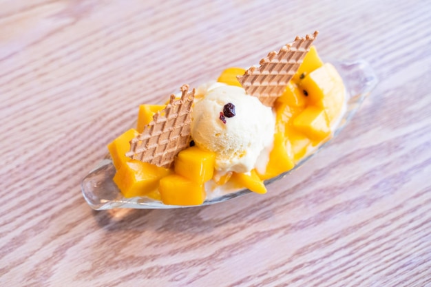 Hielo raspado de mango fresco con una bola de helado y salsa de jugo en el estilo de vida del restaurante de verano comida popular en Taiwán de cerca