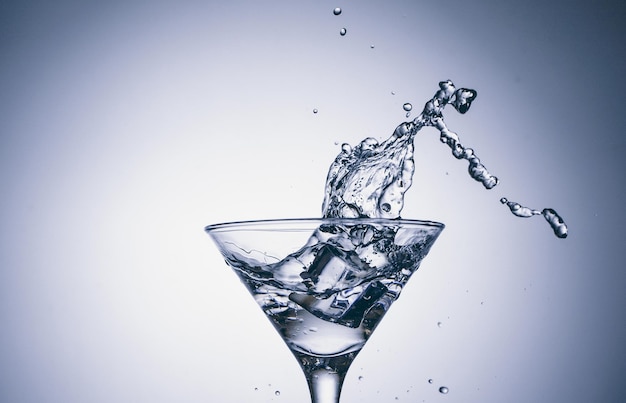 Hielo en vaso con salpicaduras de agua