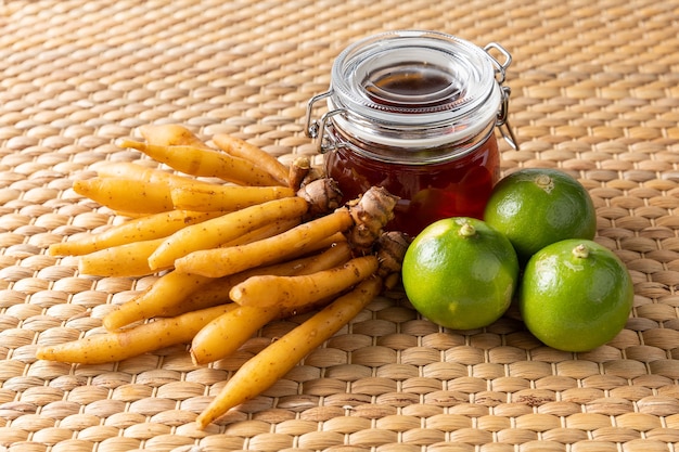 Foto hierba de raíz de dedo lima y miel sobre estera tejida de eichhornia crassipes, alimento herbal tailandés para anti covid-19