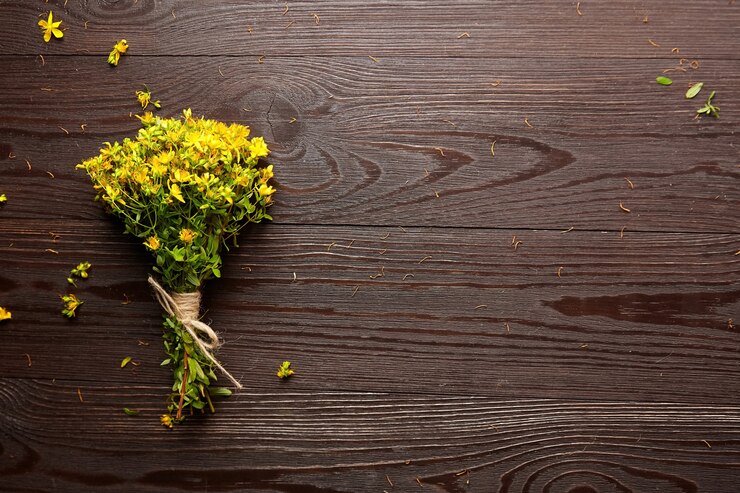 Hierba de San Juan, planta con flores amarillas, hierba curativa en la mesa de madera, vista superior.