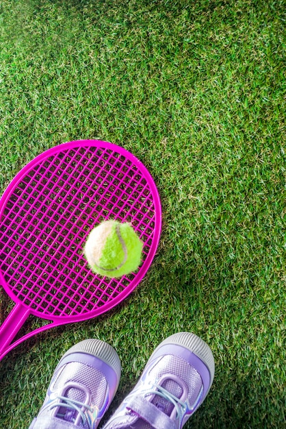 hierba verde con raqueta de tenis y pelota.