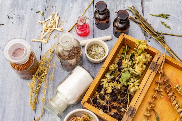 Foto hierbas aromáticas, especias y semillas en frascos y caja de madera.