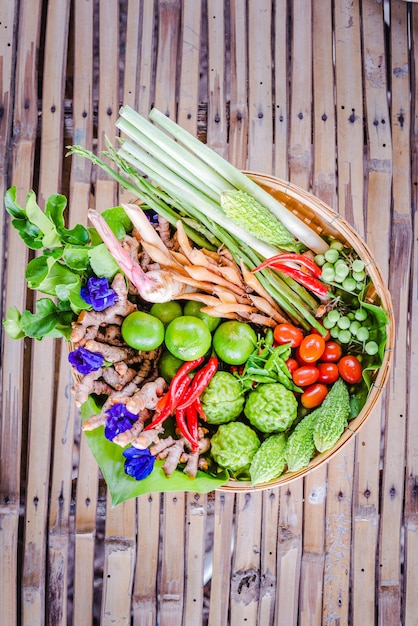 Foto hierbas asiáticas frescas e ingredientes picantes alimentos en canasta de bambú