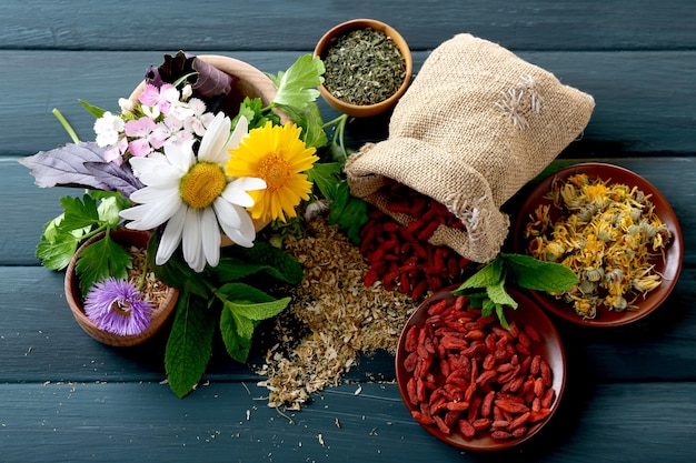 Hierbas, bayas y flores sobre fondo de mesa de madera de color