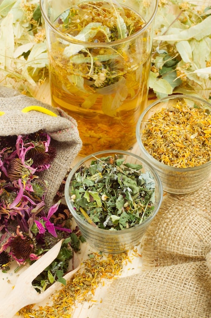 Hierbas curativas y té saludable en la medicina herbal de mesa de madera