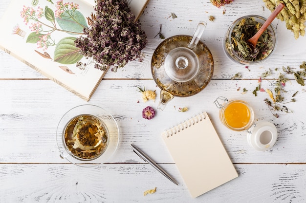 Hierbas medicinales con receta en mesa de madera. Lay Flat