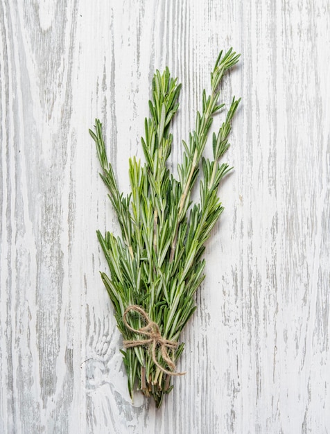 Foto hierbas de romero frescas en un montón especias aromáticas saludables sobre un fondo de madera clara