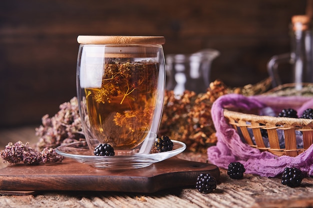 Hierbas, té de flores y moras en madera