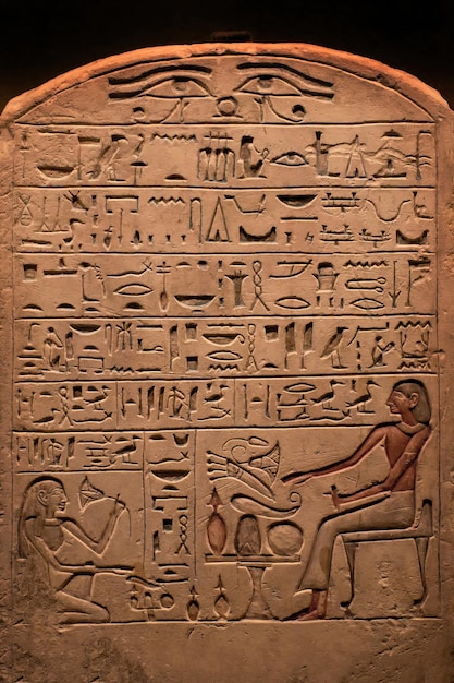 Hieroglyphisches Schnitzen auf einem alten ägyptischen Sargophagus in einem selektiven Fokus des alten Tempels