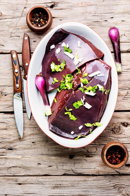 Hígado crudo crudo para cocinar en mesa de madera