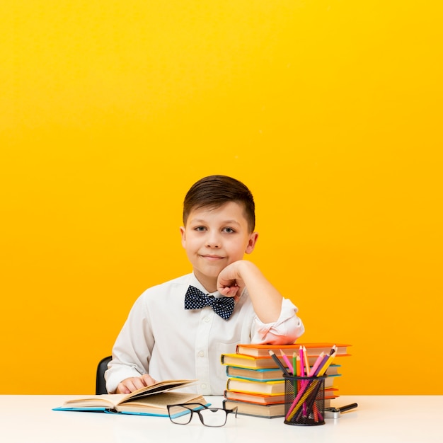 Foto high angle boy beim schreibtisch lesen