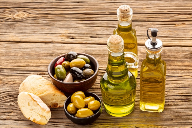 Foto high angle brotscheiben olivenschalen und ölflaschen
