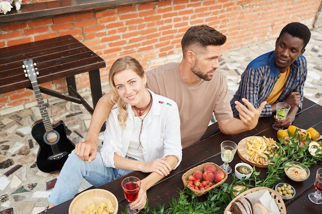 High Angle View bei einer multiethnischen Gruppe junger Leute, die das Abendessen im Freien genießen