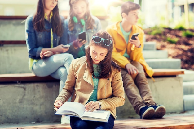 Foto high-school-studentin liest buch im freien