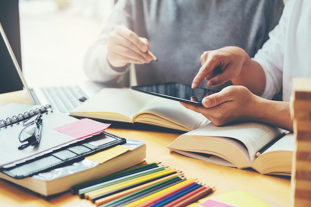 Highschool oder collegestudenten, die zusammen in der bibliothek studieren und lesen