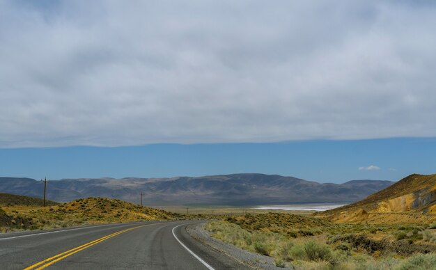 Highway lone desert road a través de la vista panorámica del cañón en Nuevo México