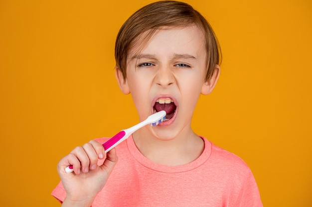 Higiene dental homenzinho escovando os dentes criança feliz garoto com escova de dentes cuidados de saúde higiene dental garotinho limpando os dentes com escova de dentes infantil
