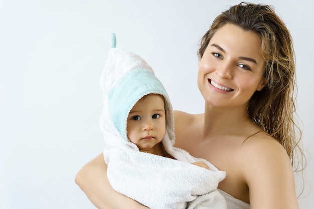 Higiene e cuidados com o bebê. jovem e feliz mãe e seu lindo filho após o banho.