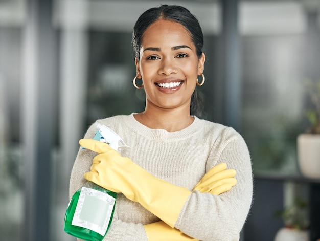 Higiene e tarefas de limpeza com um frasco de spray enquanto usava luvas e sorria em casa Retrato de uma mulher feliz, faxineira ou dona de casa pronta para fazer trabalhos domésticos para manter as coisas arrumadas e frescas