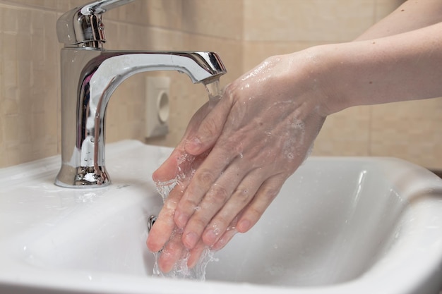 Higiene. Limpieza de manos. Lavarse las manos con agua limpia. Mano de mujer. Protégete a ti mismo