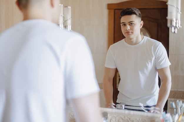 Higiene matutina, el chico se apoyó en el lavabo del baño.