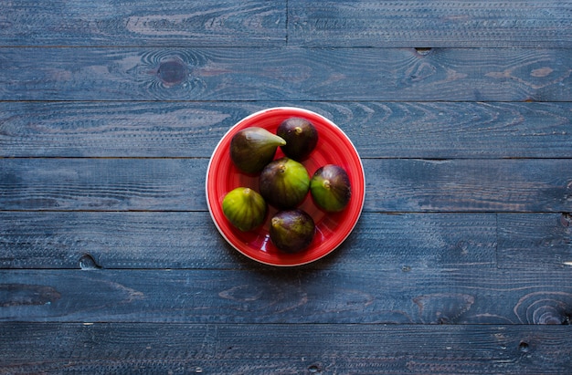 Higos frescos con duraznos, albaricoques, arándanos, fresas, en una mesa de madera