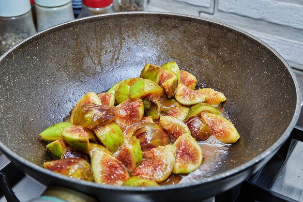 Los higos se fríen en una sartén sobre una estufa de gas, para cocinar según la receta de Internet. De cerca