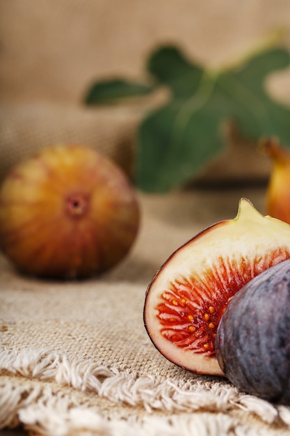 Higos en la mesa, grupo de frutas en una mesa de granja de madera con tela de arpillera