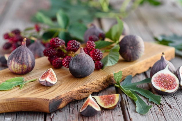 Higos y moras jugosos frescos sobre un fondo oscuro