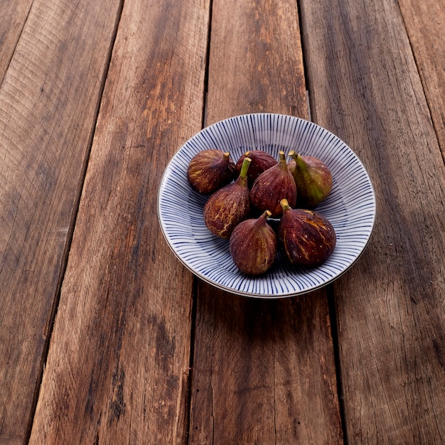 Higos en plato sobre mesa de madera