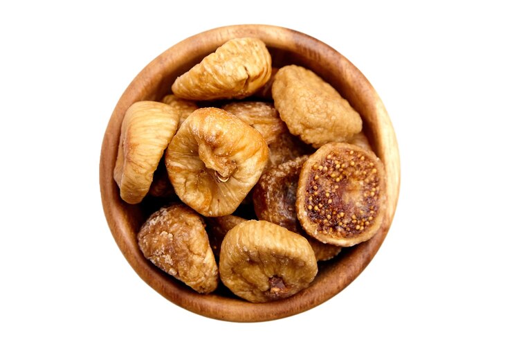Los higos secos en un cuenco de madera aislados sobre un fondo blanco vista superior Frutas secas dulces a la mitad de higos