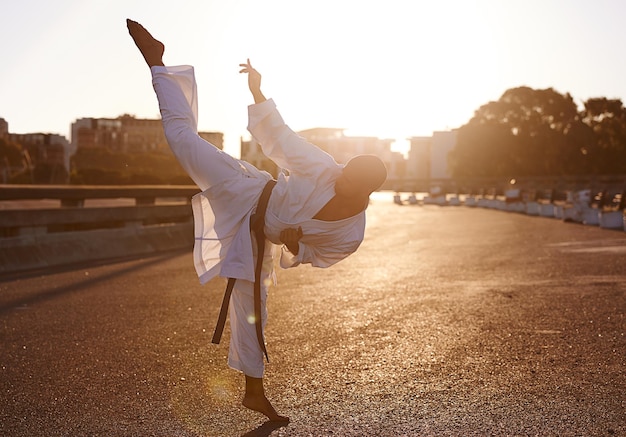 Hiiyah High kick Um jovem profissional de karatê praticando de kimono