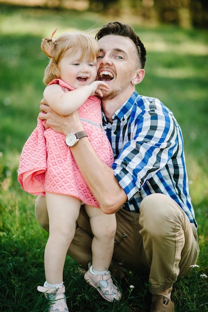 La hija abrazando al padre en la naturaleza en las vacaciones de verano Papá y niña jugando en el parque al atardecer Concepto de familia amistosa Primer plano