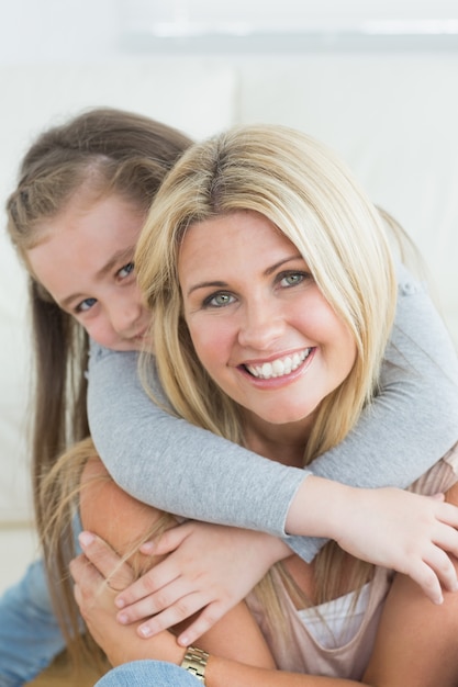 Hija abrazando a su madre desde atrás