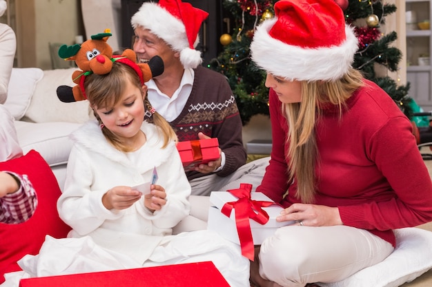 Hija abriendo el regalo de Navidad con la madre