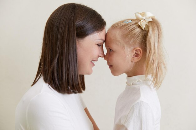 Hija alegre mirando a la madre encantada riéndose divirtiéndose