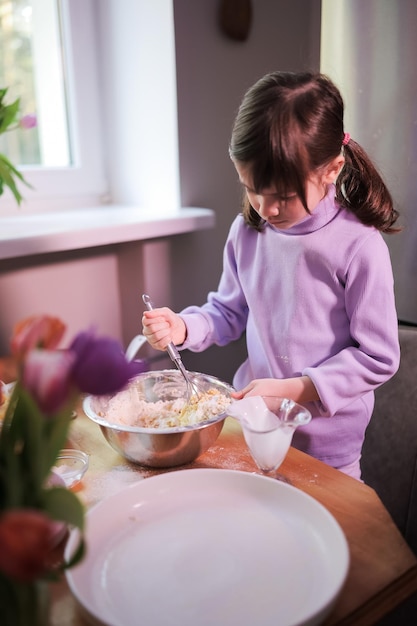 Hija amasar la masa en la cocina