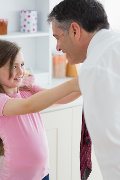 Hija arreglando la corbata de su padre